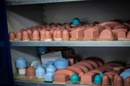 Ein Regal, gefüllt mit verschiedenen kuppelförmigen Formen, meist in Orange- und Blautönen